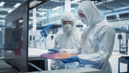 Two engineers inspecting silicon wafer.